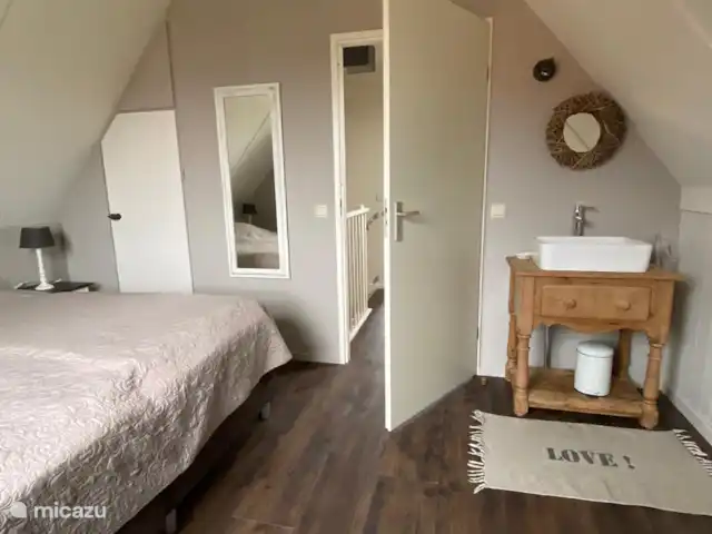 Op één van de slaapkamers op de bovenverdieping is een extra wastafel geplaatst.